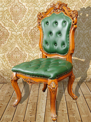 La main confortable verte a découpé les chaises en bois